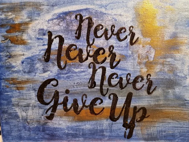 Schriftzug Never Never Never Give Up auf strukturiertem Untergrund in Blau und Gold